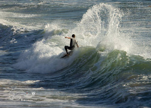 a skimboarder doing a turn on a exile skimboard in portugal